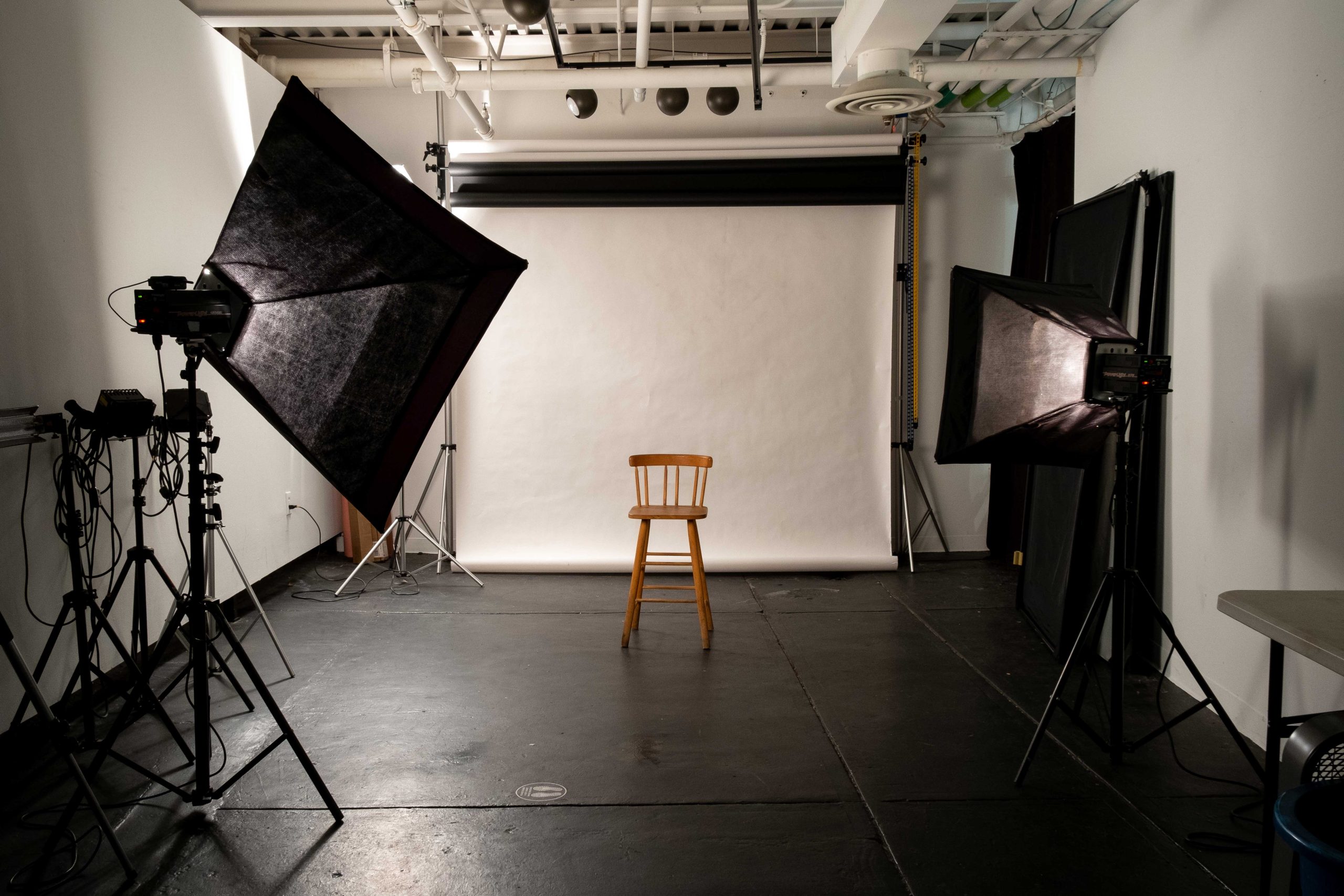 Professional photography setup with camera, lighting equipment, and a prepared studio backdrop