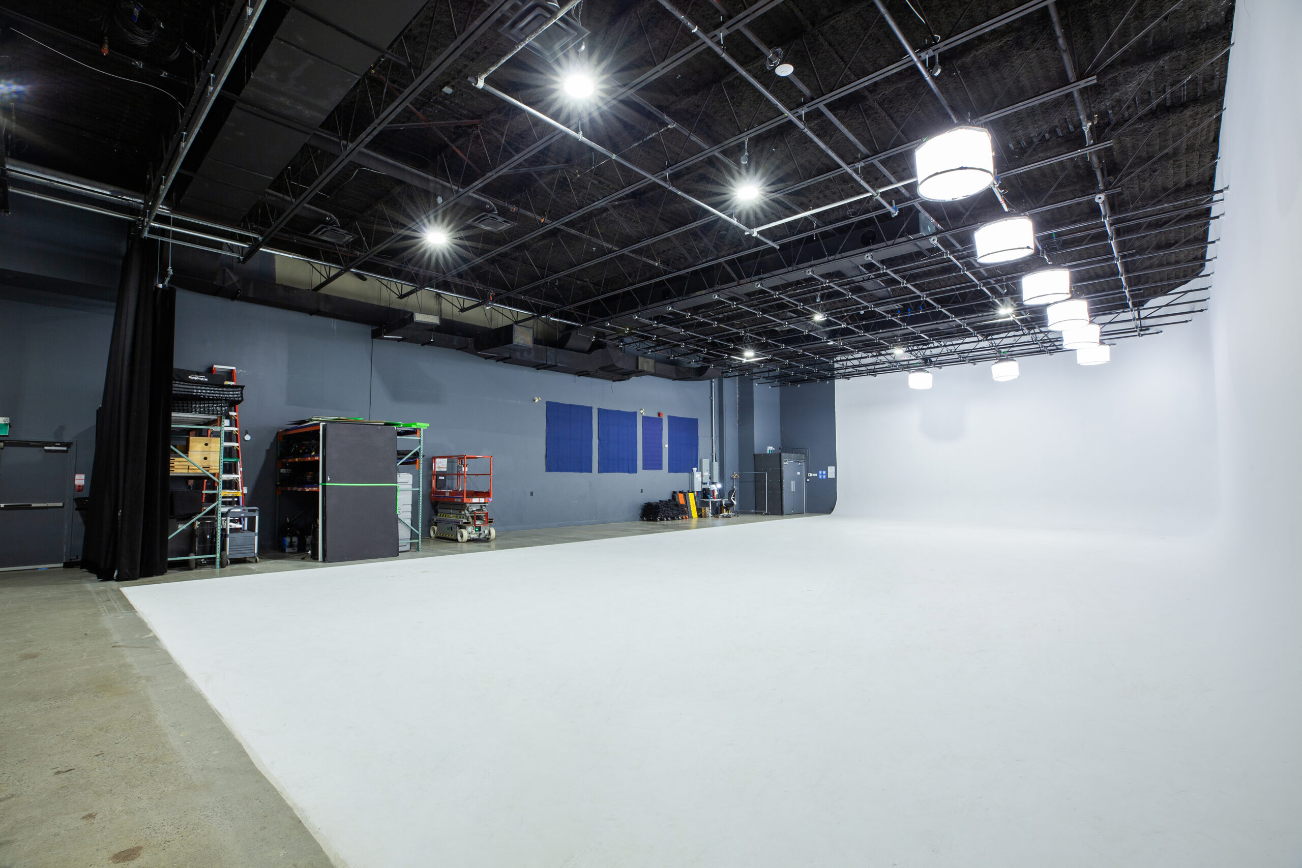 Photographer preparing studio lighting and guiding a portrait subject